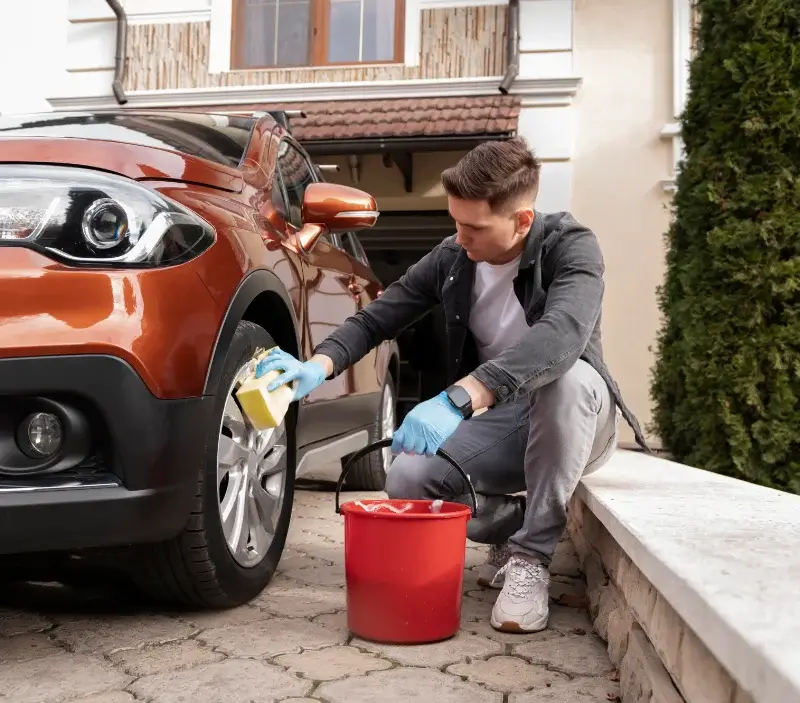Lavage auto à domicile Neufchâtel-en-Saosnois : professionnel intervenant sur un véhicule